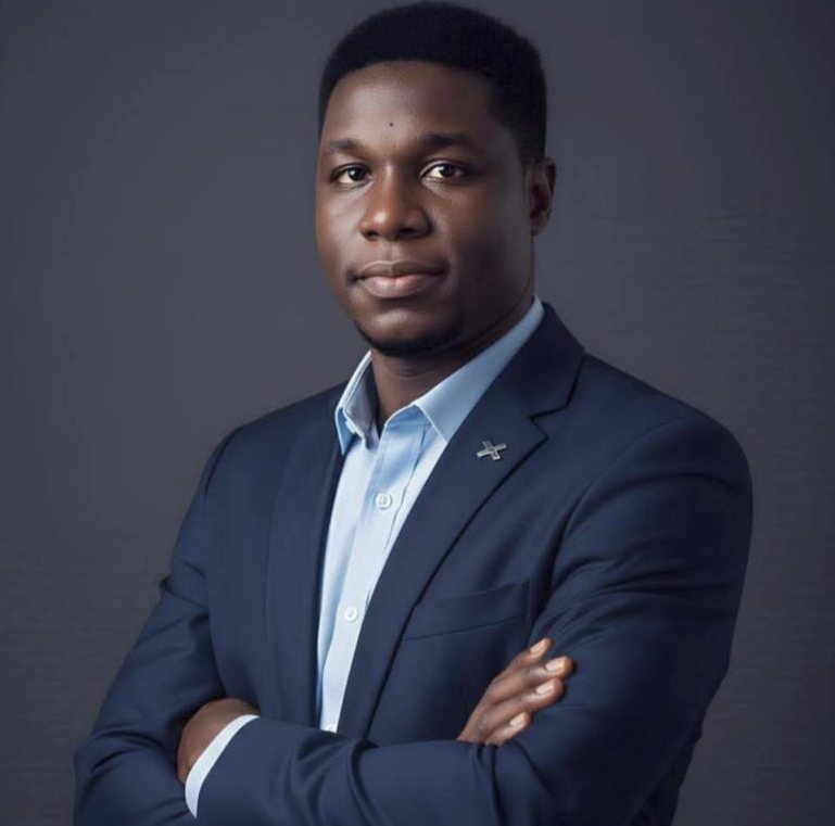 Portrait d'Emmanuel Nouhou, bras croisés, en costume bleu nuit